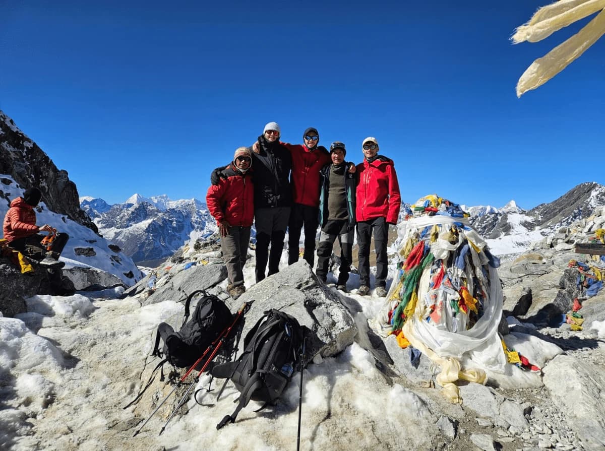 Everest Base Camp Group Joining Trek participants celebrating at Everest Base Camp (5,364m) with Mount Everest region in the background during a guided adventure by Overland Trek Nepal.