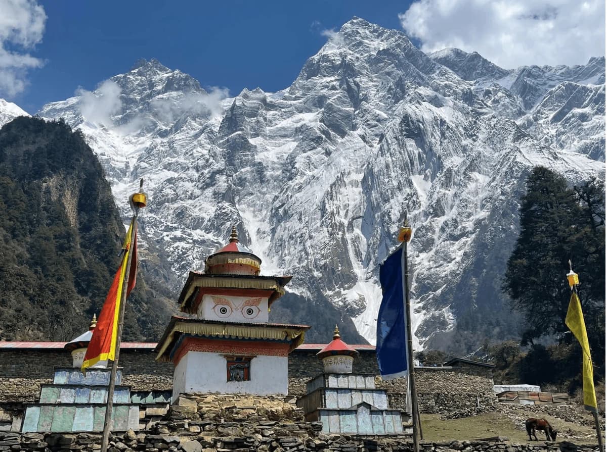Buddhist chorten with snow-covered Manaslu mountains on the Manaslu Circuit Trek